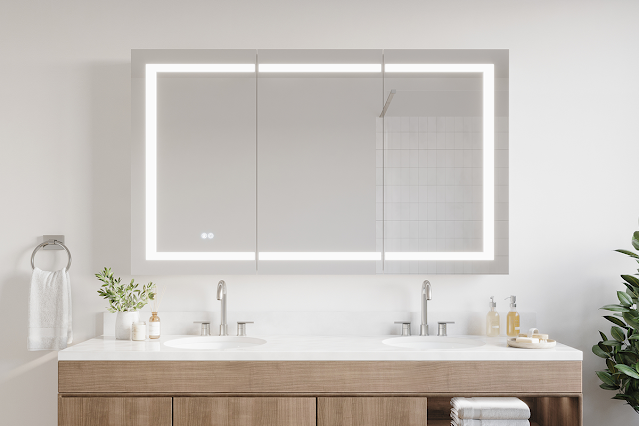 Light wood vanity with white countertop and double sinks with lighted medicine cabinet mirror overhead.